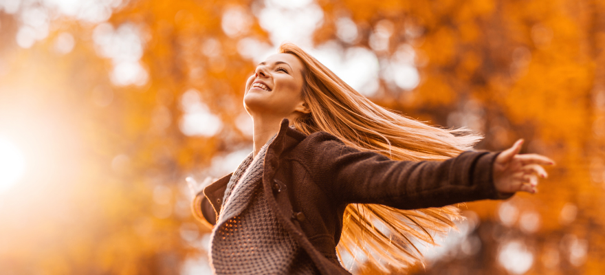 Herbstbild: Frau breitet die Arme vor Freude aus