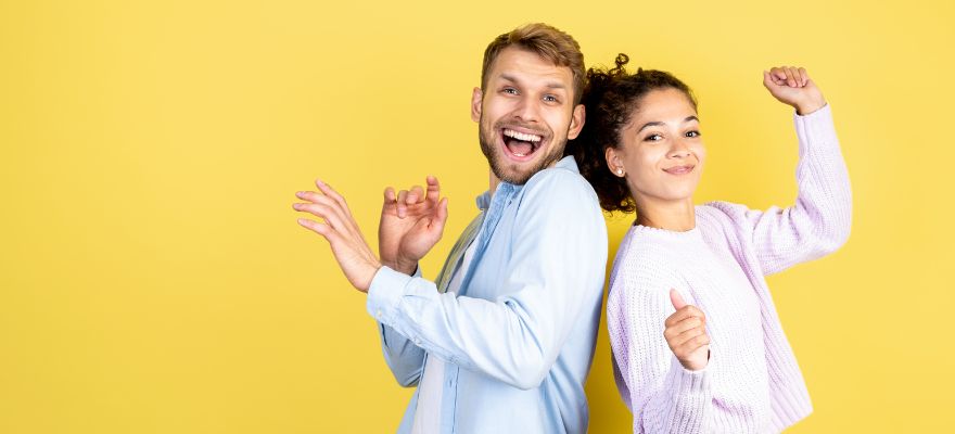 Mann und Frau jubeln vor Freude vor gelbem Hintergrund